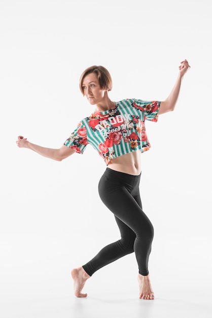 Free photo young female dancer posing against white backdrop