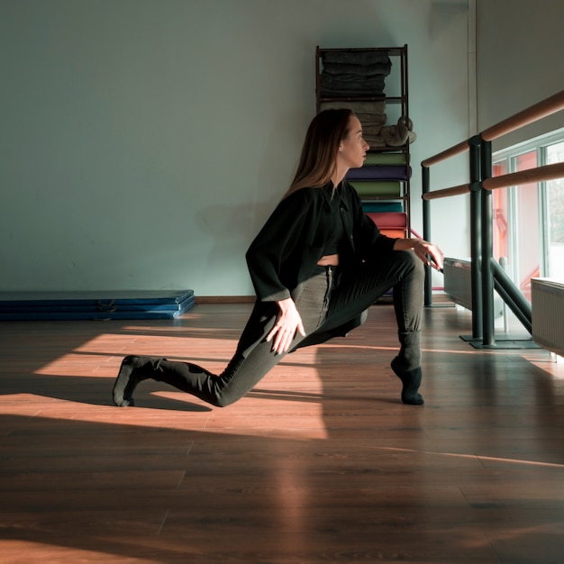 Молодая танцовщица, практикующая в танцевальной студии
