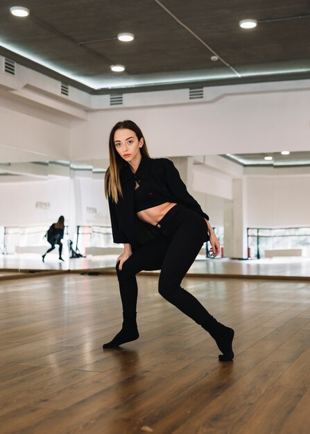 Молодая танцовщица, практикующая в танцевальной студии
