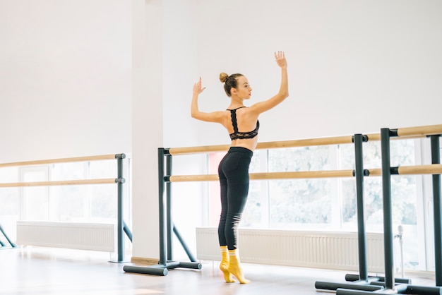 Foto gratuita giovane danzatore femminile che pratica nello studio di ballo