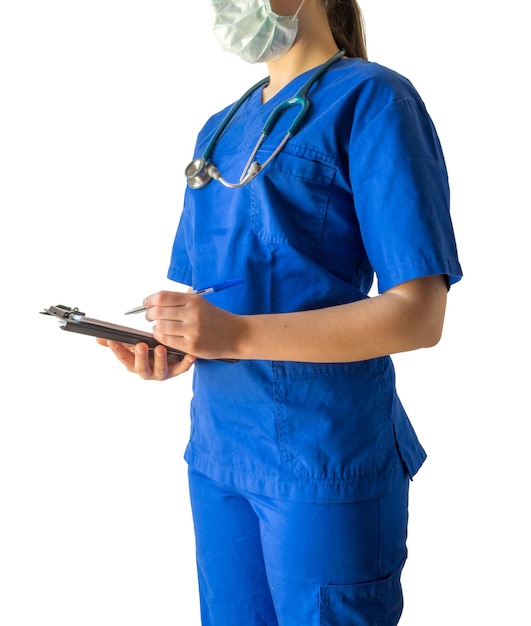 青い医療制服とノートにメモを取るマスクの若い女性医師