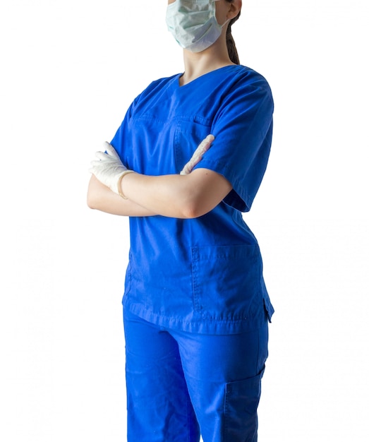 Young female doctor in a blue medical uniform standing confidently with crossed hands