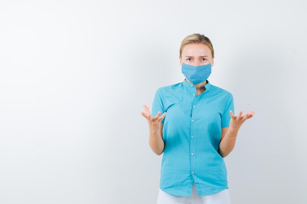 Young female doctor keeping hands in aggressive manner in medical uniform