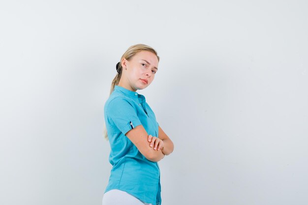 Young female doctor in medical uniform, mask standing with crossed arms