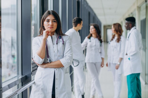Молодая женщина-врач позирует в коридоре больницы