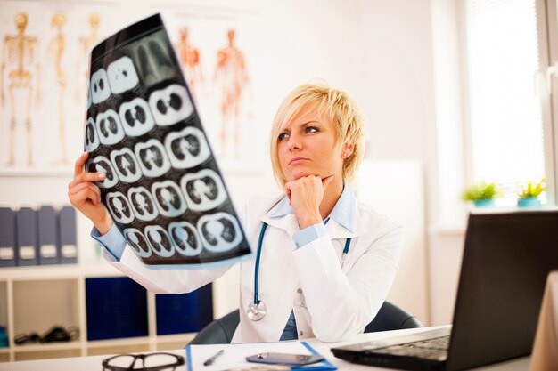 Young female doctor studying x-ray image