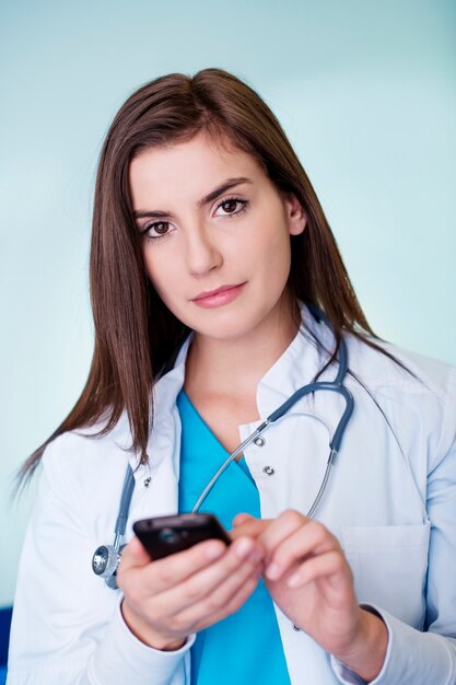 Young female doctor texting