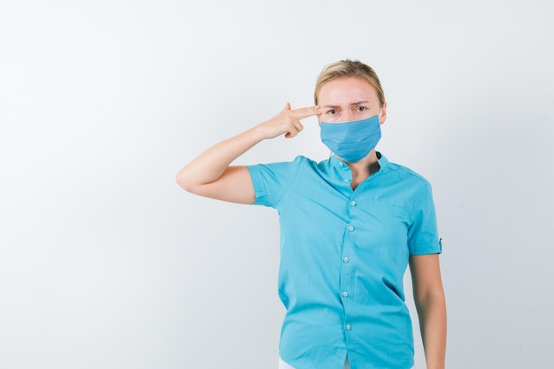 Young female doctor in uniform making suicide gesture isolated