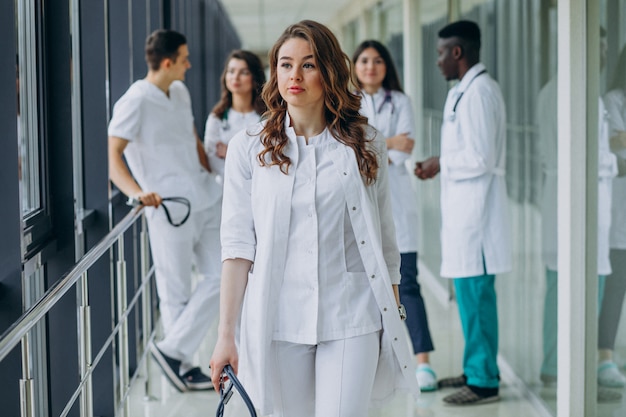 Foto gratuita giovane dottoressa a piedi dal corridoio dell'ospedale