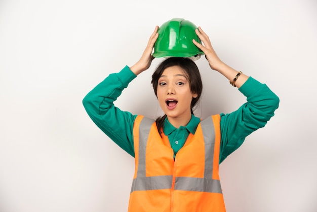 Young female engineer holding a helmet on white background. High quality photo