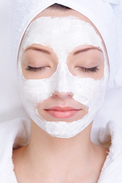 Young female face with cosmetic mask - beauty salon