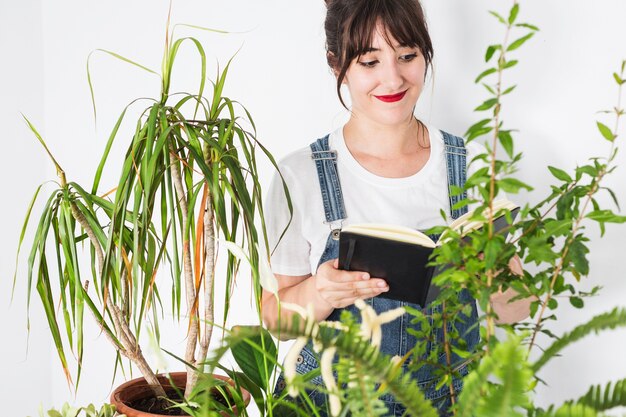 Молодая женщина-флорист с дневником, глядя на растения