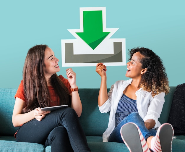 Free photo young female friends holding a download icon