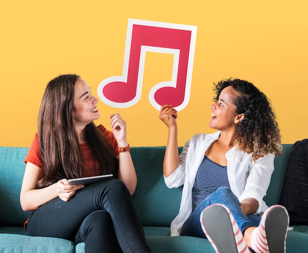 Young female friends holding a musical note icon