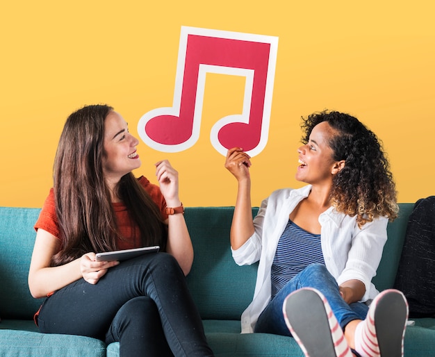 Young female friends holding a musical note icon