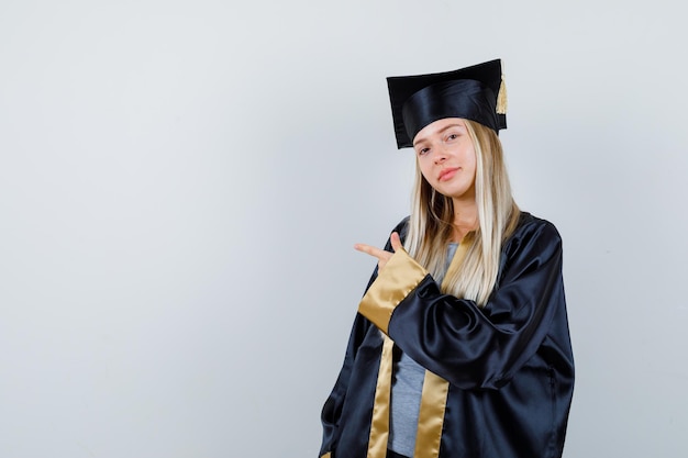 脇を向いて賢明に見える大学院の制服を着た若い女性