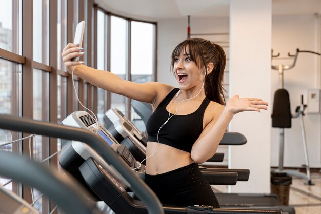 Young female at gym taking selfies