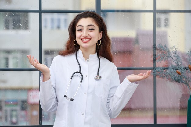 A young female health care worker open her hands wide and smiling
