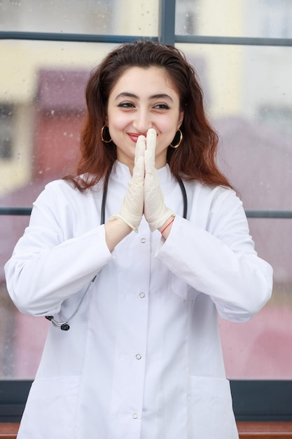 若い女性の医療従事者が手を合わせて笑顔で高品質の写真