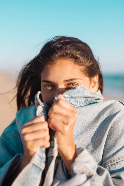 ジーンズのジャケットの若い女性隠れ顔