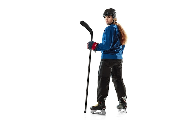 Молодая хоккеистка с клюшкой на ледовой площадке и белом фоне