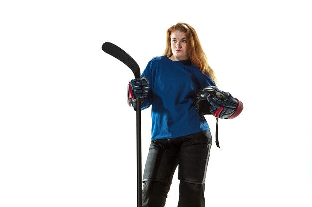 Young female hockey player with the stick on ice court and white background