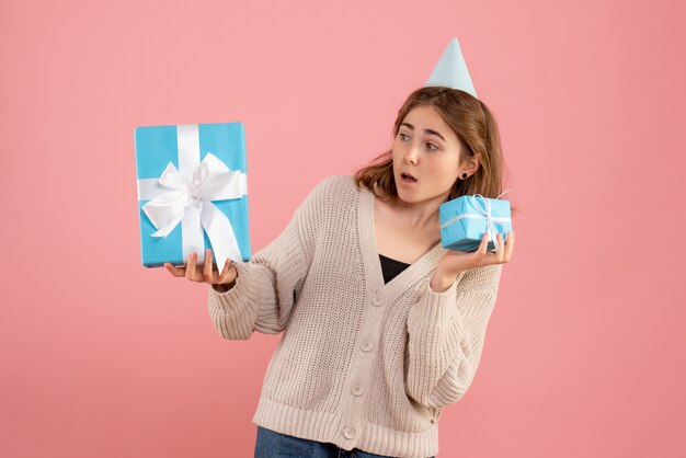 young female holding christmas presents on pink