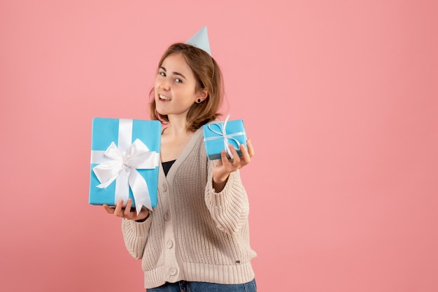 young female holding christmas presents on pink