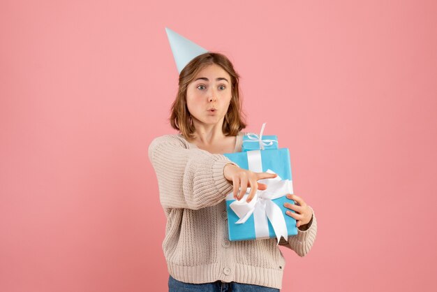 young female holding christmas presents on pink