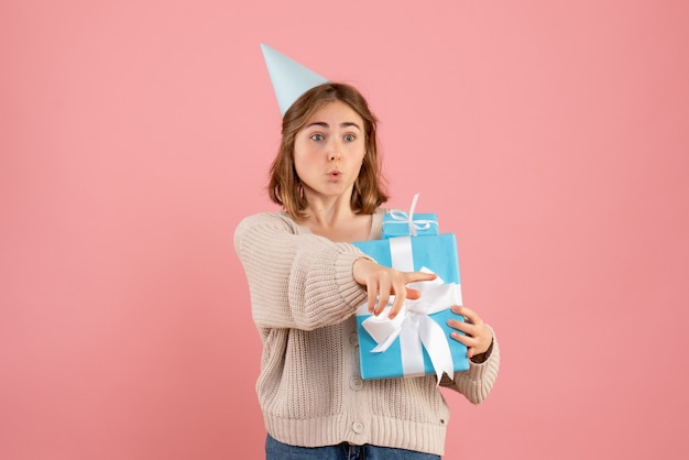young female holding christmas presents on pink