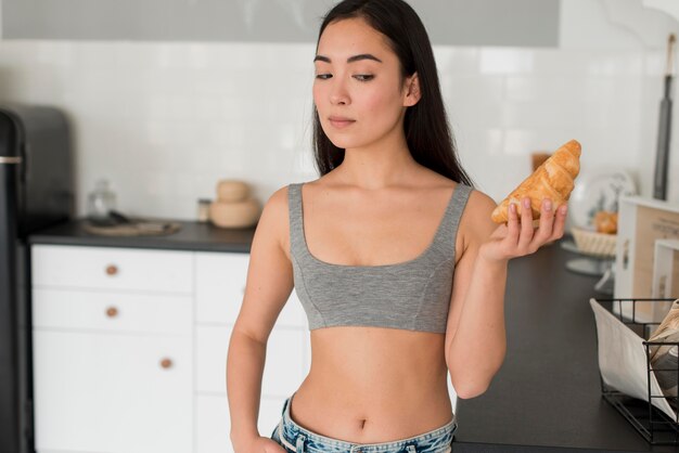 Free photo young female holding croissant