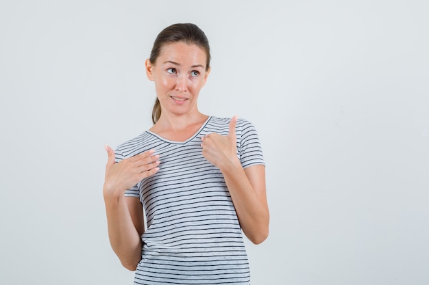 縞模様のTシャツの正面図でジェスチャーを質問で手をつないでいる若い女性。