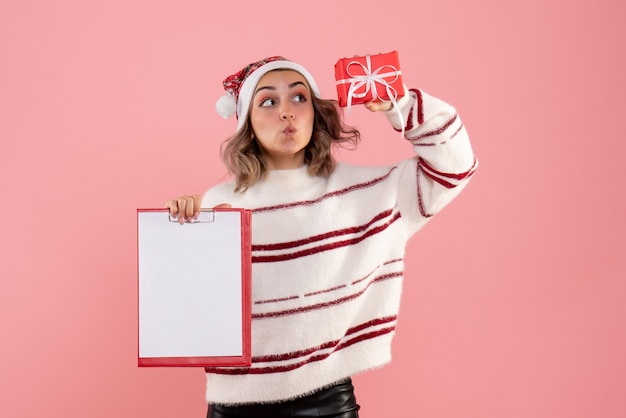 young female holding little xmas present and note on pink