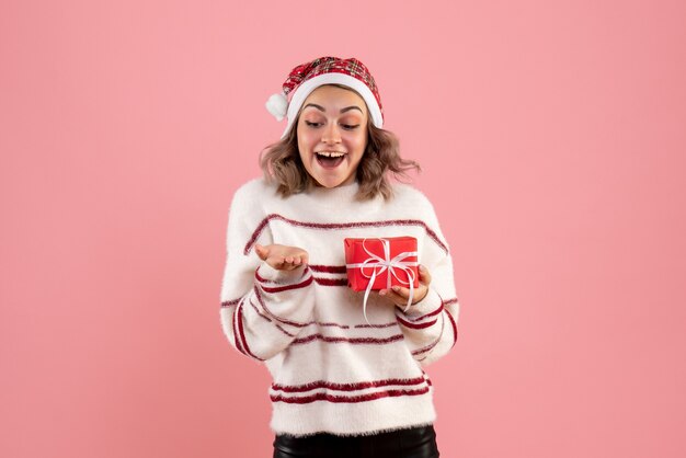 young female holding little xmas present on pink