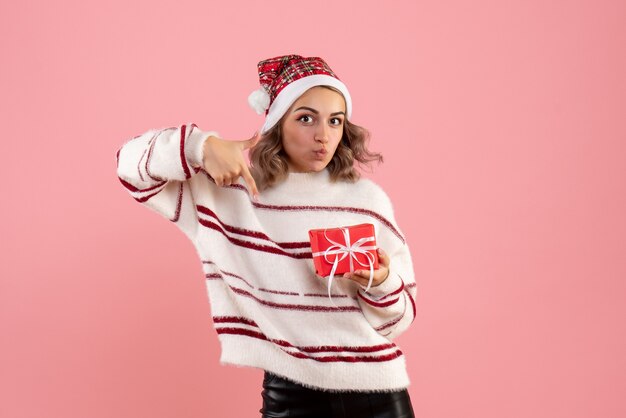 young female holding little xmas present on pink