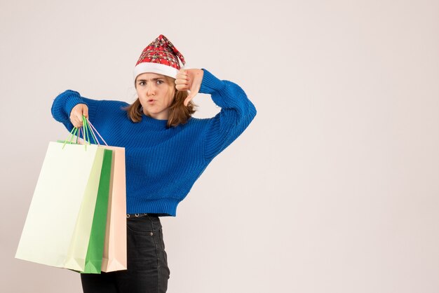 young female holding packages with presents on white