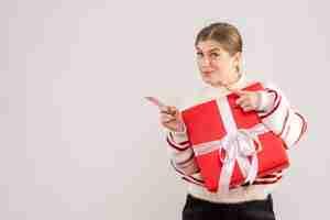 Free photo young female holding present box on white