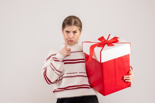 young female holding present in box on white