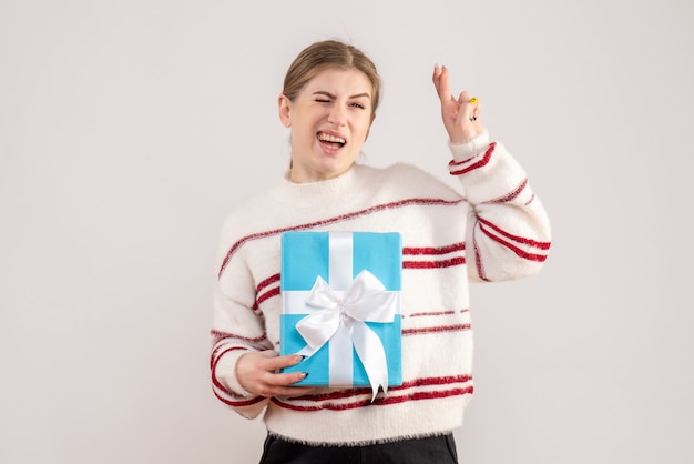 young female holding present on white