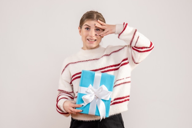 young female holding present on white