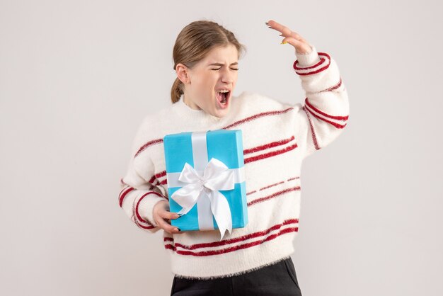 young female holding present on white