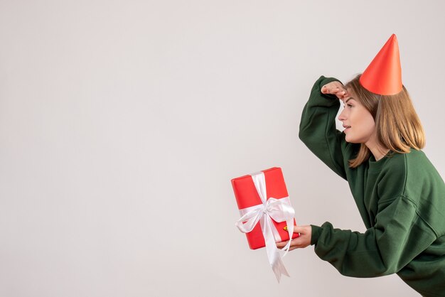 young female holding present on white