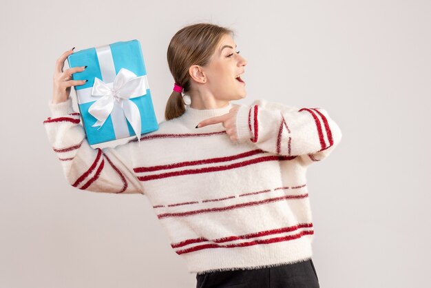 young female holding present on white