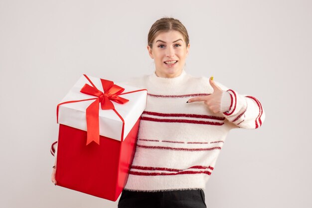 young female holding red present on white