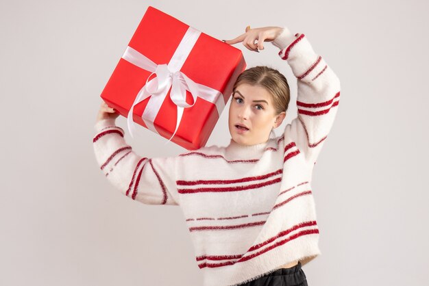 白に赤いプレゼントを保持している若い女性