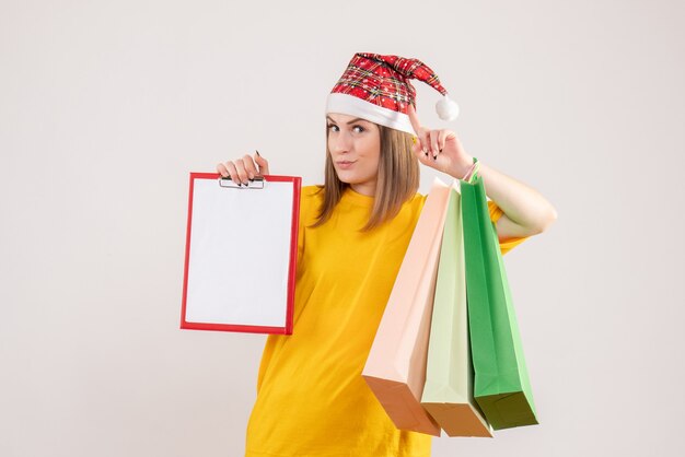ショッピングパッケージと白のメモを保持している若い女性