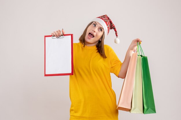 young female holding shopping packages and note on white