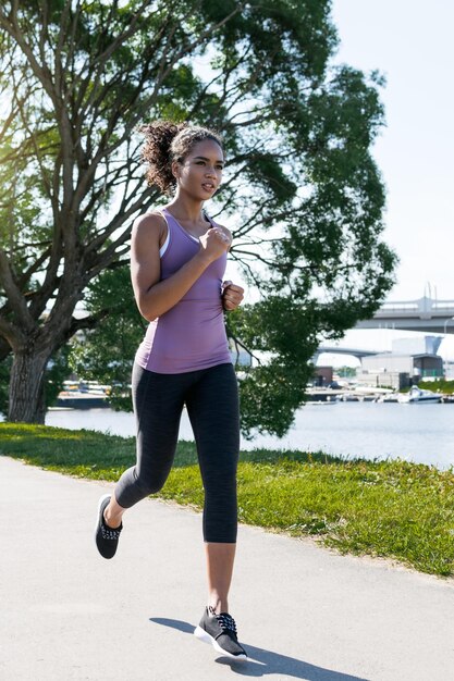 Young female jogger doing exercising outdoors in park