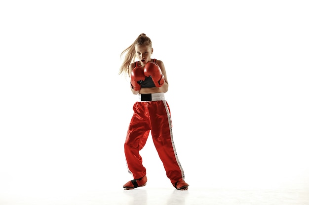 若い女性のキックボクシングの戦闘機のトレーニングは、白い背景で隔離。
