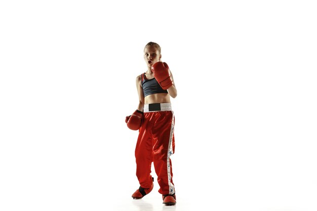 Young female kickboxing fighter training isolated on white background